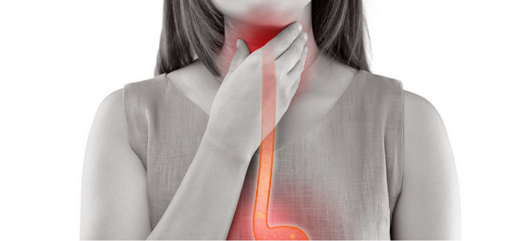 woman's hand at her throat, suggesting throat discomfort