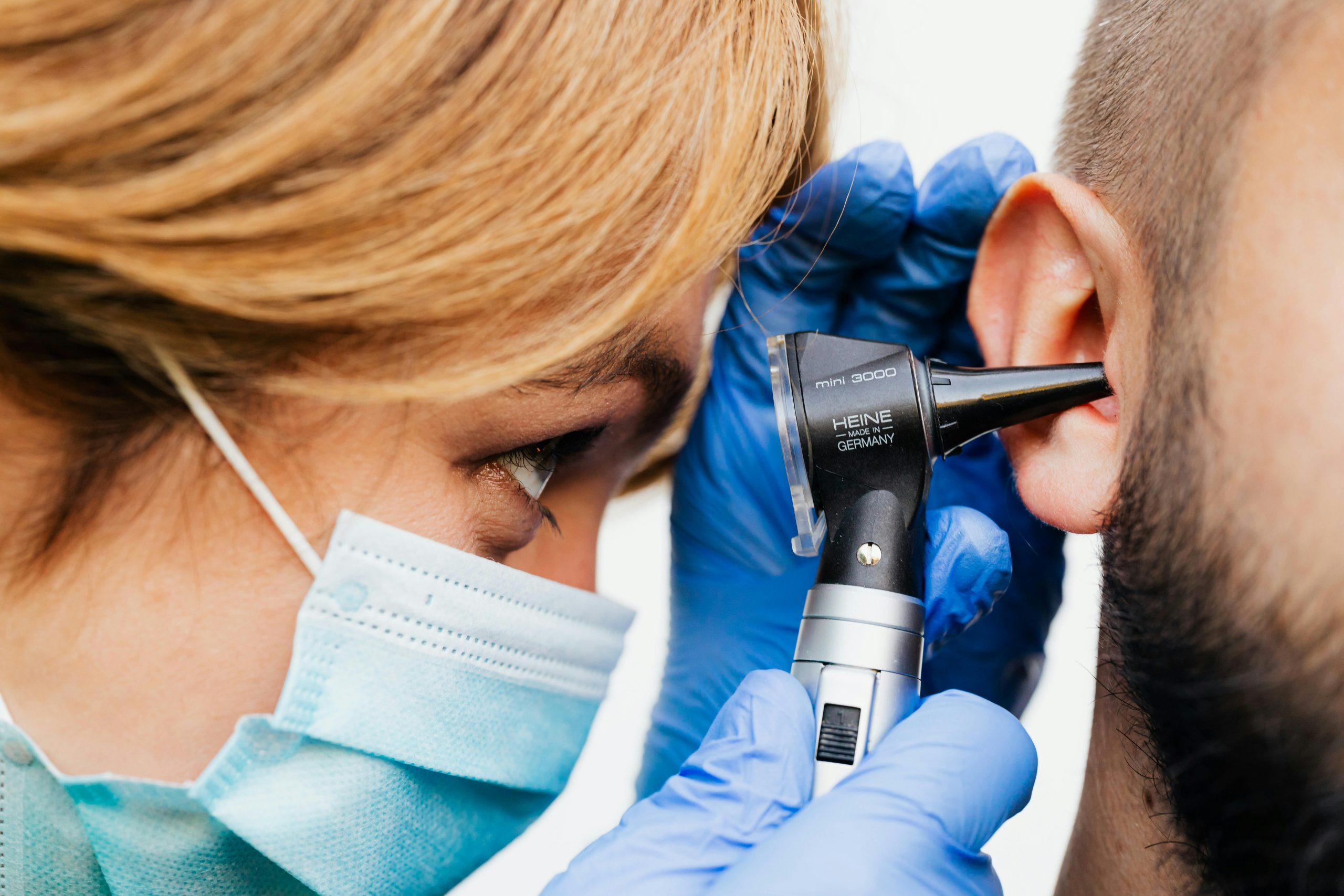 doctor holding an otoscope to a patient's ear